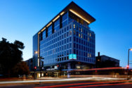 Outdoor evening photo of the exterior of the AC Hotel Madison Downtown backlighting from the setting sun.